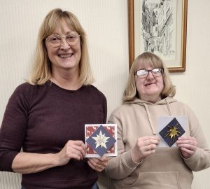 Two blonde haired ladies with cards they have made